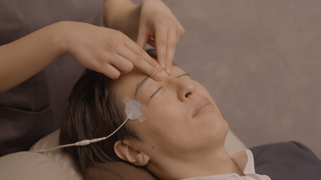 皺眉筋の揉みほぐしを受ける男性