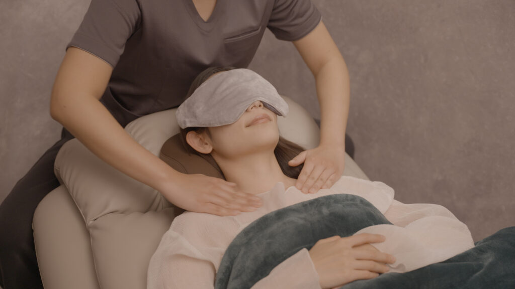 目の痛みに対する施術を行う女性と、施術を受ける女性