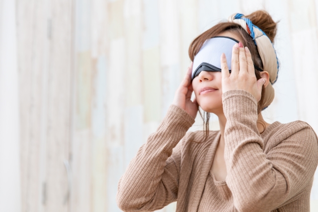 目のチカチカを改善する温罨法を試す女性